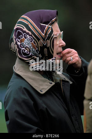 La regina Elisabetta II, indossando occhiali, un copricapo e una giacca verde cerata. Mordere il dito e guardare ansioso. The Royal Windsor Horse Show, 1989 Foto Stock