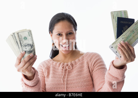 Una donna in possesso di un passaporto biglietti di aereo e di dollari Foto Stock