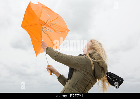 Donna, lottando con ombrellone Foto Stock