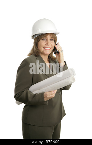 Un felice sorridente architetto femmina holding blueprint e parlando sul suo cellulare isolato Foto Stock