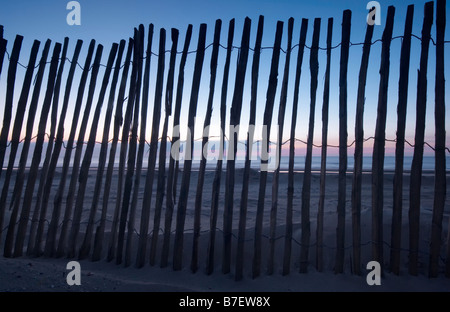 Staccionata in legno sulla spiaggia con lo sfondo del tramonto Foto Stock