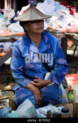 Bajau donna con cappello di vimini seduta nel mercato, Kota Belud, Malaysia Foto Stock