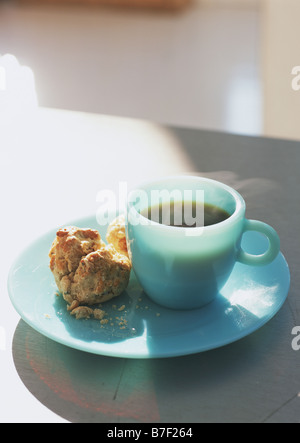 Una tazza di caffè e cornetto sul piatto Foto Stock