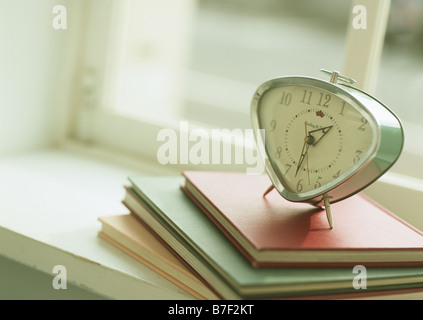 Libri e sveglia Foto Stock