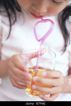 Ragazza di bere succo di frutta con paglia Foto Stock