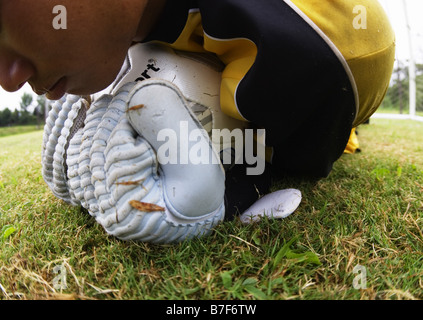 Il portiere raggiungendo per pallone da calcio Foto Stock