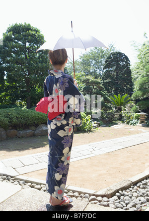 Donna vestita Yukata holding ombrellone Foto Stock