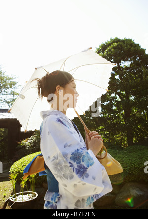 Donna vestita Yukata holding ombrellone Foto Stock