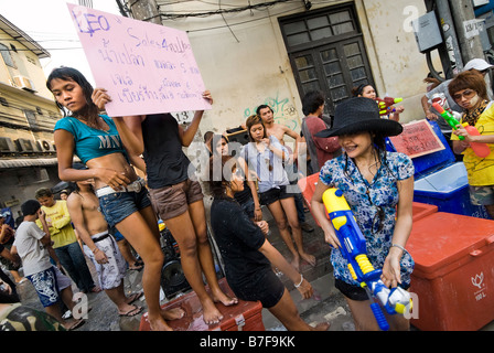 I giovani sul ciglio della strada a guardare il Thai per i festeggiamenti di capodanno di Songkran festival dell'acqua Banglamphu Bangkok in Thailandia Foto Stock