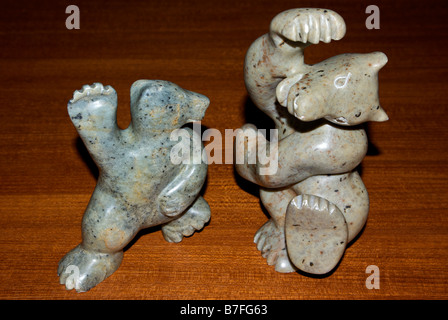 Arte Inuit dancing bear sculture scolpite in pietra ollare sul tavolo in teak Foto Stock