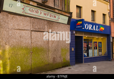 Chiuso e intavolato shop accanto al Coral betting shop nel centro della città di Llanelli Carmarthenshire West Wales UK Foto Stock