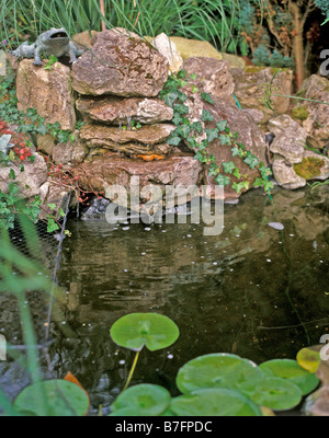 Una piccola cascata in giardino Foto Stock