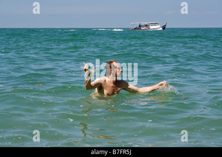 Uomo con i rifiuti raccolti dal mare durante una nuotata. Foto Stock