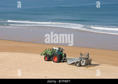 Il trattore azionato spiaggia macchina di pulizia. Foto Stock