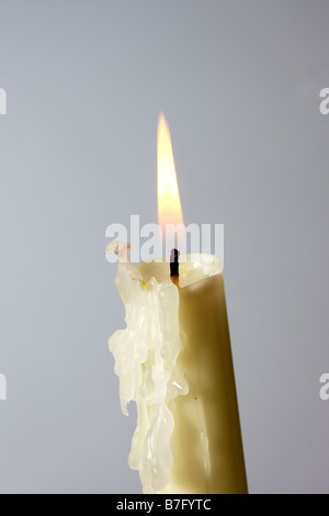 Candela accesa con sfondo grigio Foto Stock