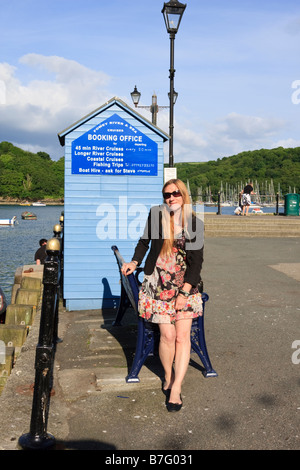 Donna attraente in occhiali da sole in attesa per il traghetto Polruan, sulla banchina di Fowey Foto Stock