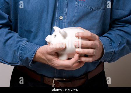 Un uomo che impugnano un prezioso salvadanaio Foto Stock