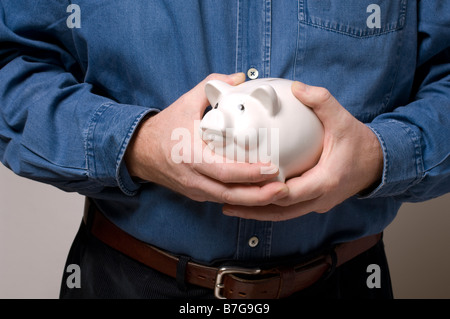 Un uomo che impugnano un prezioso salvadanaio Foto Stock
