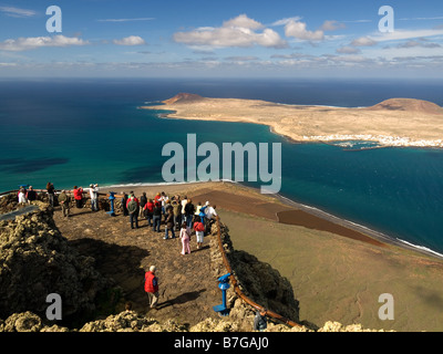 I turisti guardano in tutta l'isola di La Graciosa dal Mirador del Rio viewpoint a Lanzarote isole Canarie Foto Stock