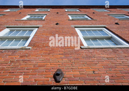 Guardando verso l'alto lato del vecchio edificio in mattoni con finestre in Claremont, New Hampshire Foto Stock