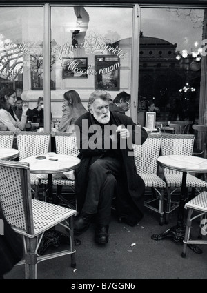 Parigi, Francia. Uomo di sigarette di rotolamento esterno cafe Foto Stock