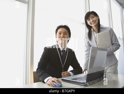 Sorridente imprenditori, indossando vestiti in ufficio Foto Stock