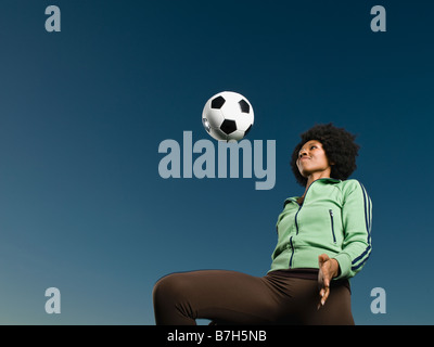 Donna africana kneeing pallone da calcio Foto Stock