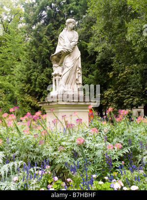 Una statua di pietra e graziosi fiori nel Jardin du Luxembourg a Parigi, Francia Europa Foto Stock