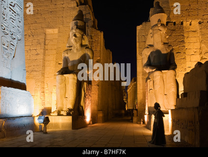 Tempio di Luxor Luxor Egitto. Primo pilone con obelisco e colossi di Ramesse II, crepuscolo Foto Stock