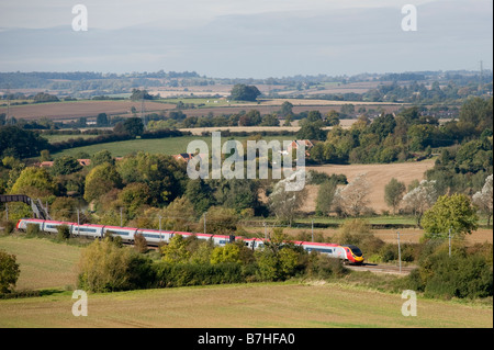 Classe 390 treno pendolino in livrea vergine accelerando attraverso la campagna inglese e sulla linea principale della costa occidentale Inghilterra Foto Stock