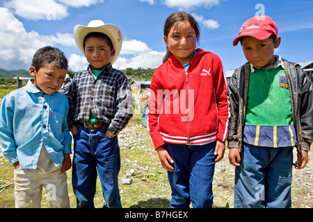 Tre ragazzi e una ragazza pone vicino a una chiesa di San Nicolas Highlands Occidentali Guatemala Foto Stock