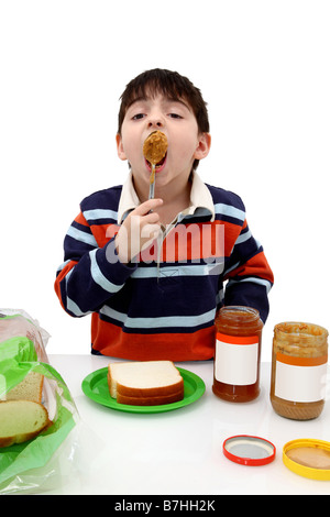 Adorabile ragazzo che il burro di arachidi e gelatina panini Foto Stock