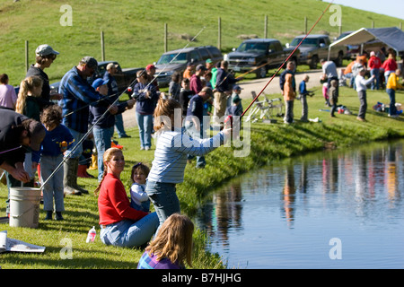 Un gruppo di famiglie di pesca in un stagno durante un derby di pesca Foto Stock