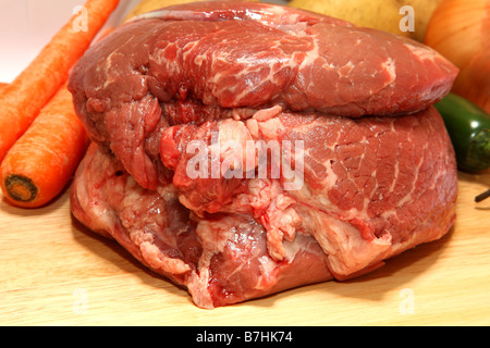 Materie arrosto di manzo sul tagliere con verdure in background Foto Stock