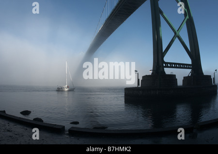 Vela in nebbia sotto il ponte Lions Gate Bridge, Vancouver, British Columbia Foto Stock