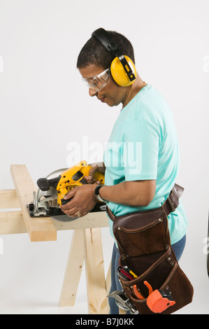 African American donna facendo Home Improvement, legname di taglio con una sega di specialità, B.C. Foto Stock