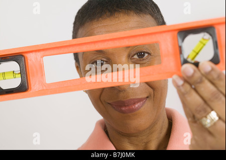 African American donna facendo Home Improvement, utilizzando un livello di spirito, B.C. Foto Stock