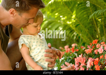 Papà & baby guardando/profumati fiori, Regina, Saskatchewan Foto Stock