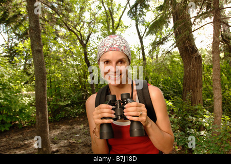 Donna nei boschi con il binocolo, Regina, Saskatchewan Foto Stock