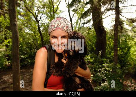 Donna escursionista con il cane nei Boschi, Regina, Saskatchewan Foto Stock
