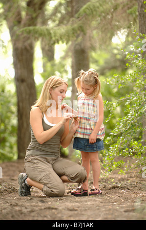 Giovane donna e bambino nei boschi guardando paesaggi, Regina, Saskatchewan Foto Stock