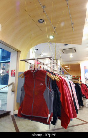 Warm climbing clothing for women on sale on a suspended clothing rail Foto Stock
