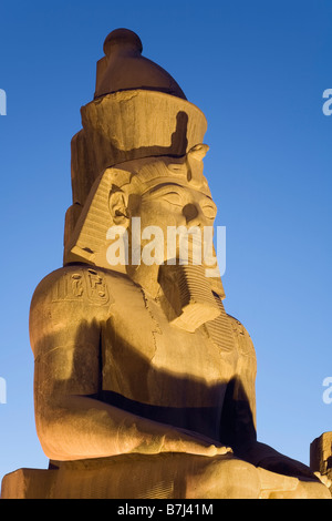 Tempio di Luxor Luxor Egitto. Il colosso di Ramesse II nella grande corte, crepuscolo Foto Stock