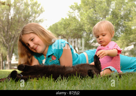 Ragazza giovane, baby & cat su erba, Regina, Saskatchewan Foto Stock