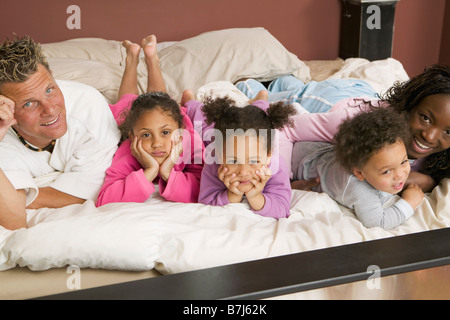 AA mamma, papà caucasico, Mulatto bambini, ragazzo 1,5 anni, ragazza 3 anni, ragazza 6 anni. In letto. Foto Stock