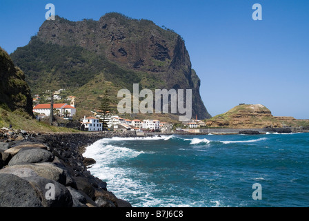 dh ` PORTO da CRUZ MADEIRA Eagle Rock villaggio e sciabiche che si infrangono sulla costa rocciosa nord costa penha de aguia paesaggio costa Foto Stock