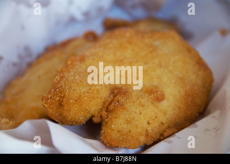 Australian pesce fritto avvolto in macelleria carta per estrarre lo sgombro qui è impanati e martoriato di scaglie al di sotto di esso. Foto Stock