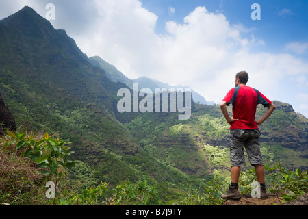 Escursionista guardando scenario sul Kalalau Trail Costa Na Pali Parco Nazionale di Kaua'i Hawaii USA Foto Stock