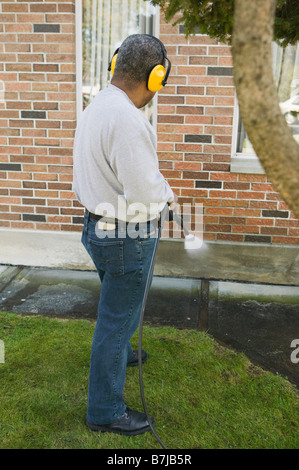 African American uomo utilizzando una rondella di potenza, Vancouver, BC Foto Stock