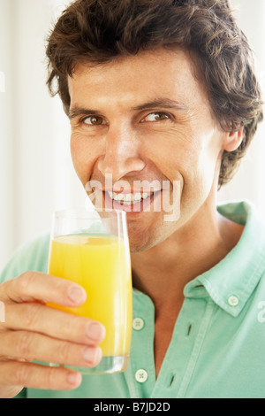 Metà uomo adulto bere un bicchiere di succo di arancia Foto Stock